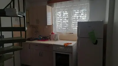 a kitchen with a refrigerator and a stove and a window at Apartmani Primorski hrast in Bar