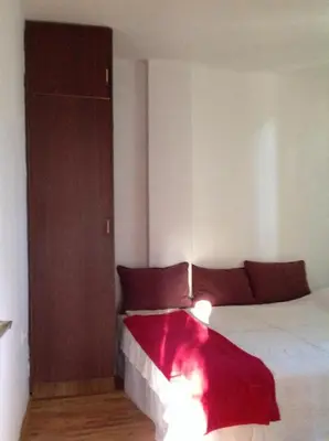 a bedroom with a bed with a red blanket on it at Apartmani Primorski hrast in Bar