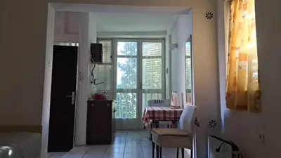 a dining room with a table and a window at Apartmani Primorski hrast in Bar