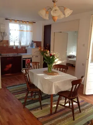 a dining room table with a vase of flowers on it at Apartmani Primorski hrast in Bar