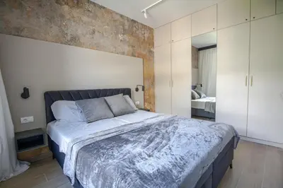 a bedroom with a large bed with a brick wall at Luxury 1-Bedroom close to the beach in Rafailovici in Rafailovici