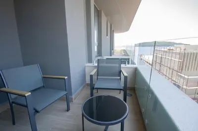 two chairs and a table on a balcony at Luxury 1-Bedroom close to the beach in Rafailovici in Rafailovici
