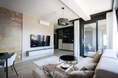 a living room with a white couch and a tv at Luxury 1-Bedroom close to the beach in Rafailovici in Rafailovici