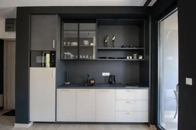 a kitchen with white cabinets and a refrigerator at Luxury 1-Bedroom close to the beach in Rafailovici in Rafailovici