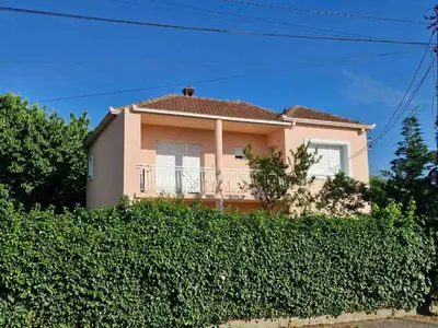 a house with a hedge in front of it at Guest house PG in Podgorica