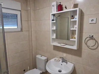 a bathroom with a toilet and a sink and a mirror at Guest house PG in Podgorica