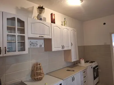 a kitchen with white cabinets and a counter top at Guest house PG in Podgorica