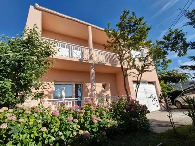 a house with flowers in front of it at Guest house PG in Podgorica