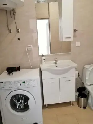 a bathroom with a washing machine and a sink at Sun&Sea Apartments in Dobra Voda