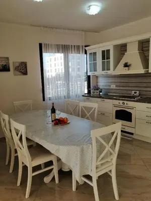 a kitchen with a table with a bowl of fruit on it at Sun&Sea Apartments in Dobra Voda