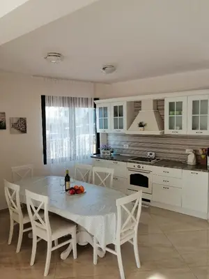 a kitchen with a table with a bottle of wine at Sun&Sea Apartments in Dobra Voda