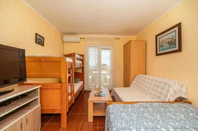 a small room with a bed and a tv and a bedroom at Sea House Apartments in Bar