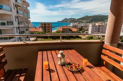 a plate of food on a wooden table on a balcony at Sea House Apartments in Bar