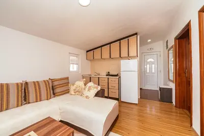 a living room with a couch and a kitchen at Sea House Apartments in Bar