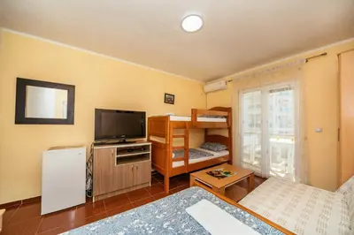 a small living room with a television and a bed at Sea House Apartments in Bar
