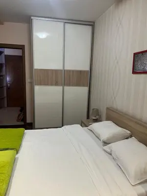 a bedroom with a white bed and a glass door at Central Podgorica Suite in Podgorica