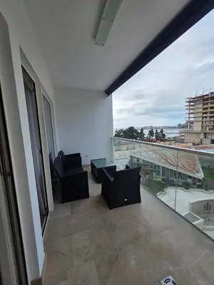 a balcony with two chairs and a large window at Orenda Residences- Sea View Apartment in Budva