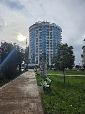 a building with a bench in a park at Orenda Residences- Sea View Apartment in Budva