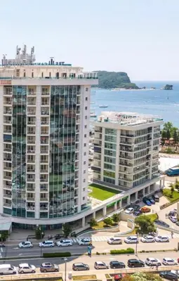an aerial view of two tall buildings next to a parking lot at Orenda Residences- Sea View Apartment in Budva