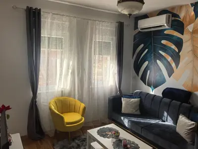 a living room with a blue couch and a yellow chair at relaxroom Podgorica in Podgorica