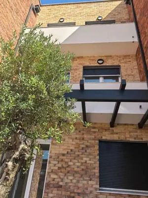 a brick building with a black balcony on it at relaxroom Podgorica in Podgorica