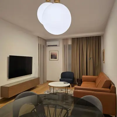 a living room with a couch and a tv at Premium apartments with garage in Podgorica