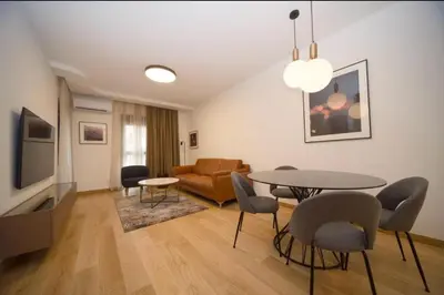 a living room with a table and chairs and a couch at Premium apartments with garage in Podgorica