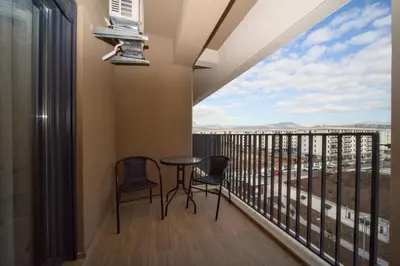 a balcony with a table and chairs and a large window at Premium apartments with garage in Podgorica