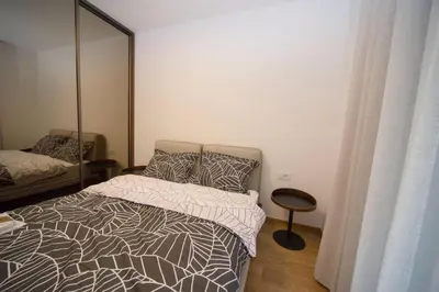 a bedroom with a bed and a mirror at Premium apartments with garage in Podgorica