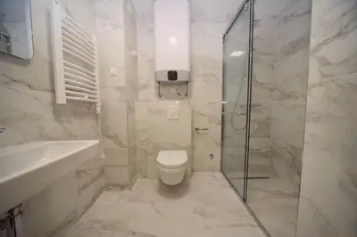 a bathroom with a shower and a toilet and a sink at Premium apartments with garage in Podgorica