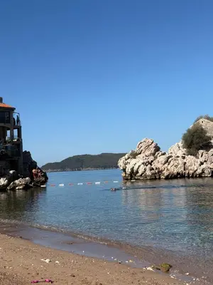 a body of water with a beach and rocks at Val Apartment, Przno in Budva