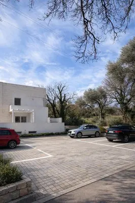 two cars parked in a parking lot in front of a building at Val Apartment, Przno in Budva