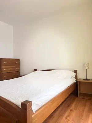 a bedroom with a bed and a night stand with a lamp at Квартира in Budva