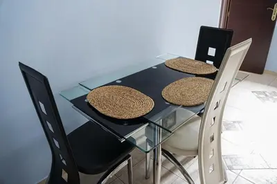 a glass table with three straw hats on it at Green Garden Villa in Becici