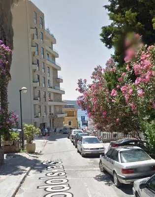 a street with cars parked on the side of the road at Apartman Vuk in Rafailovici