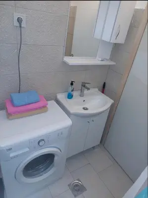 a bathroom with a washing machine and a sink at Podgorica apartment in Podgorica