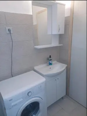 a bathroom with a washing machine and a sink at Podgorica apartment in Podgorica