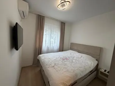 a small bedroom with a bed and a television at KAZOSA Sea Apartment in Becici
