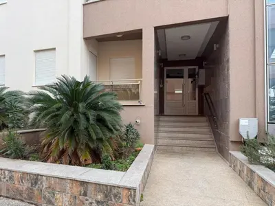 a building with a door and a palm tree in front of it at KAZOSA Sea Apartment in Becici