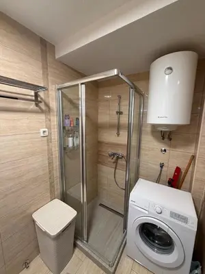 a bathroom with a shower and a washing machine at KAZOSA Sea Apartment in Becici