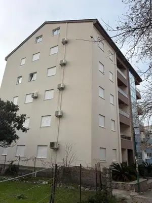 a large white building with windows on the side of it at KAZOSA Sea Apartment in Becici