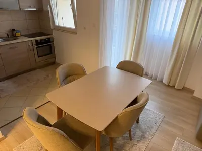 a kitchen with a table and chairs in a room at KAZOSA Sea Apartment in Becici