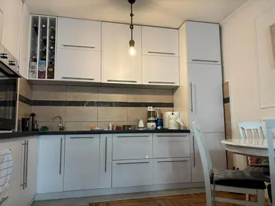 a kitchen with white cabinets and a table at LuxeStay Ksenija apartment in Podgorica