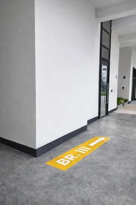 a yellow exit sign on the floor of a building at Urban Forest Apartment - with free Garage in Podgorica