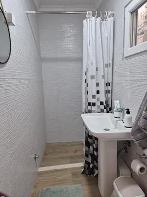a white bathroom with a sink and a shower at Amore Studio Apartment in Bar, Susanj