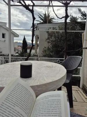 a table with two books and a coffee cup on it at Amore Studio Apartment in Bar, Susanj
