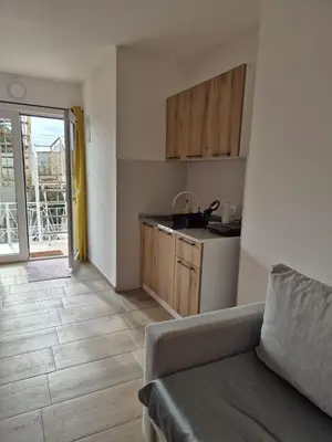 a living room with a couch and a kitchen at Amore Studio Apartment in Bar, Susanj