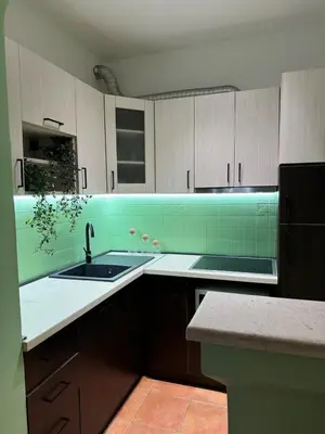 a kitchen with a sink and a green tiled wall at Blue Sea apartment Petrovac in Petrovac na Moru