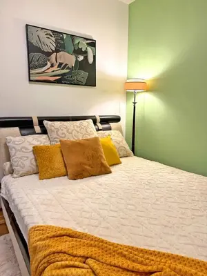 a bedroom with a large bed with yellow pillows at Blue Sea apartment Petrovac in Petrovac na Moru