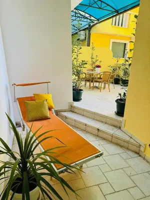 a patio with a bed and a table and chairs at Blue Sea apartment Petrovac in Petrovac na Moru